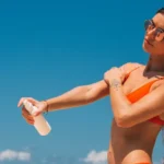 Ragazza che applica abbronzante con protezione solare